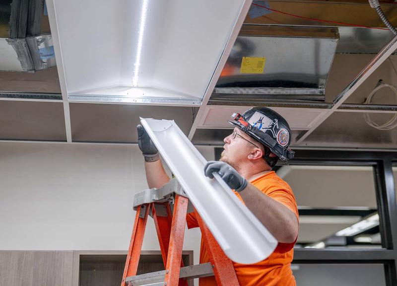 McElroy Electric technician completes installation of energy-efficient LED ceiling light.